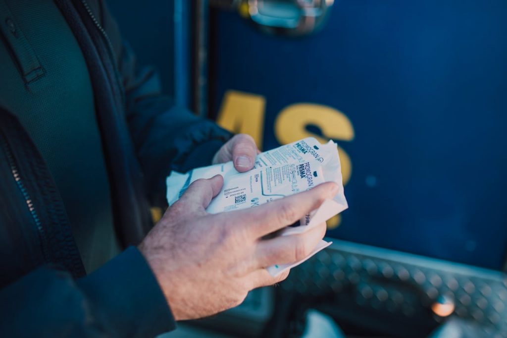 Hands holding medical gauze in preparation for emergency care outside.