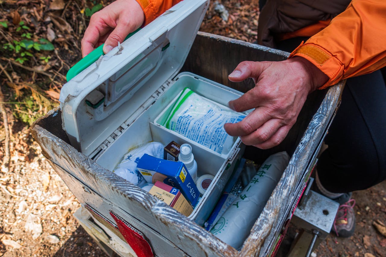 A hiker opens a first aid kit during an outdoor adventure in Dazaifu, Japan.
